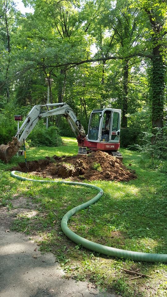 Miller Septic excavator working a wooded job site